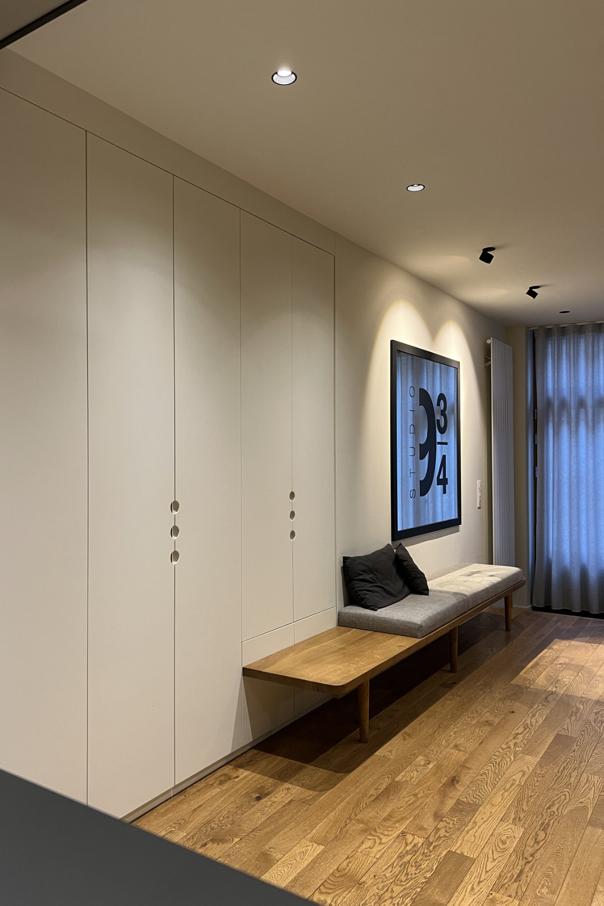 Linéaire de placards intégrés et banquette bois massif avec assise en tissus