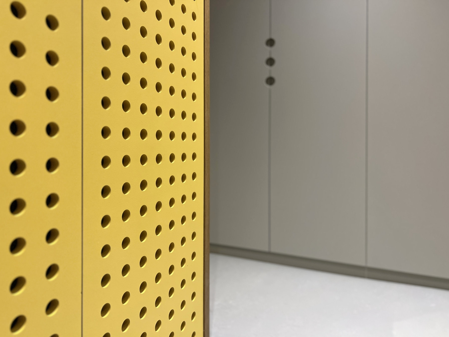 Détail sur parement en panneaux jaunes perforés