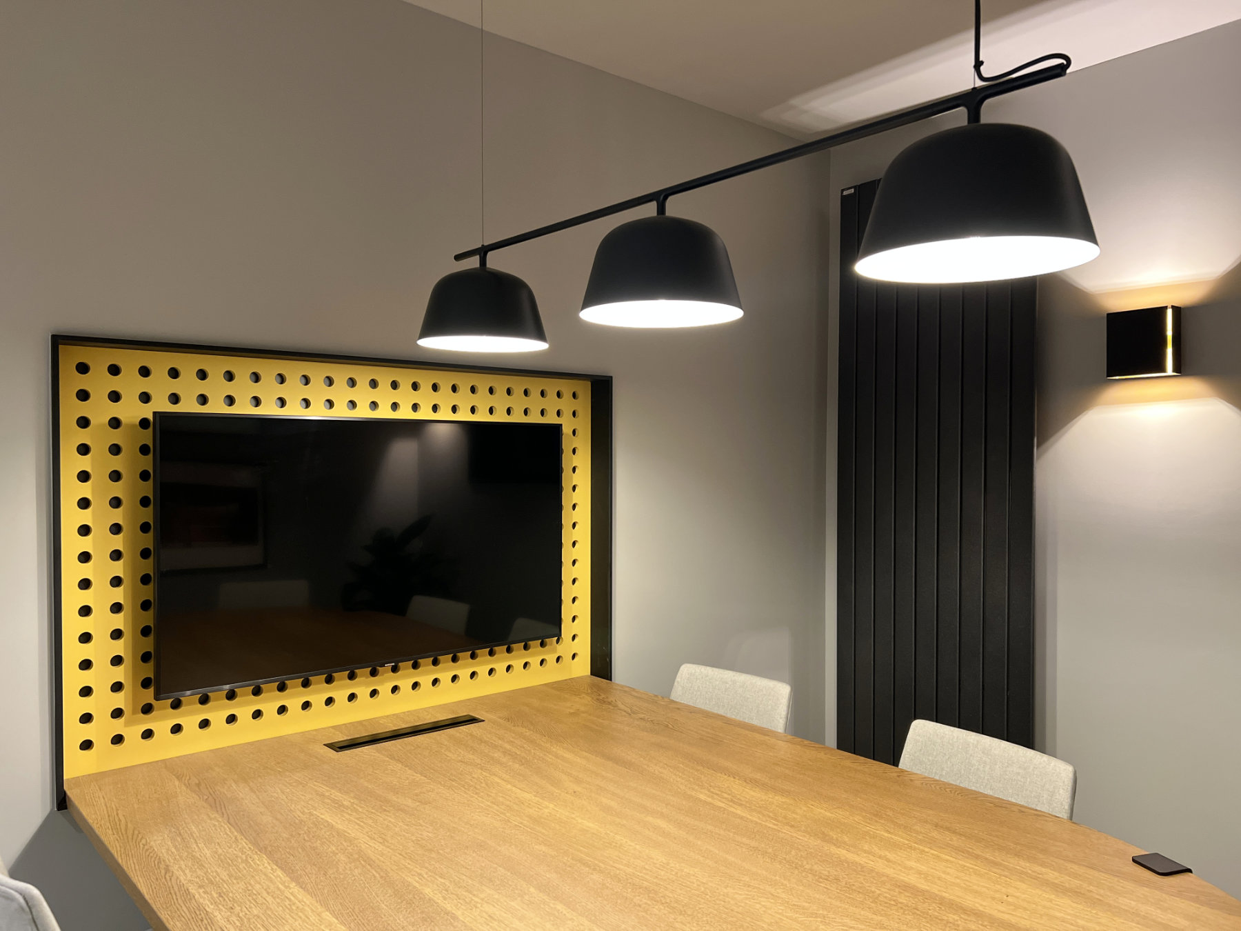 Table de réunion avec écran de projection dans alcôve jaune