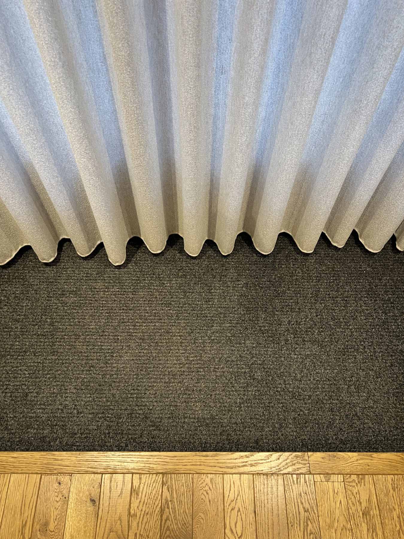 Détail rideaux tombant sur tapis