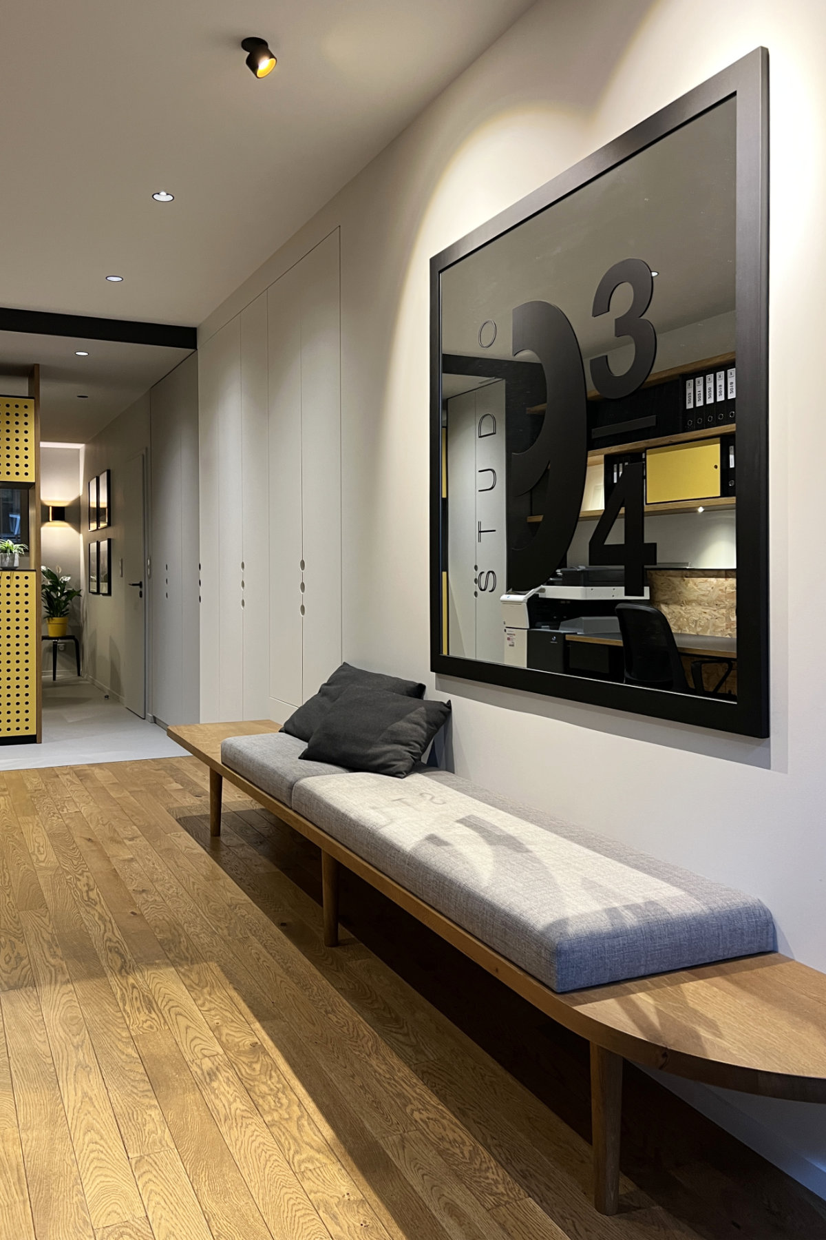 Banquette bois élancée avec assise tissus surmontée d'un miroir avec logo studio 9 3/4